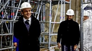 French President Emmanuel Macron (L) walks inside the nave during a visit of the reconstruction work at the Notre-Dame de Paris Cathedral.