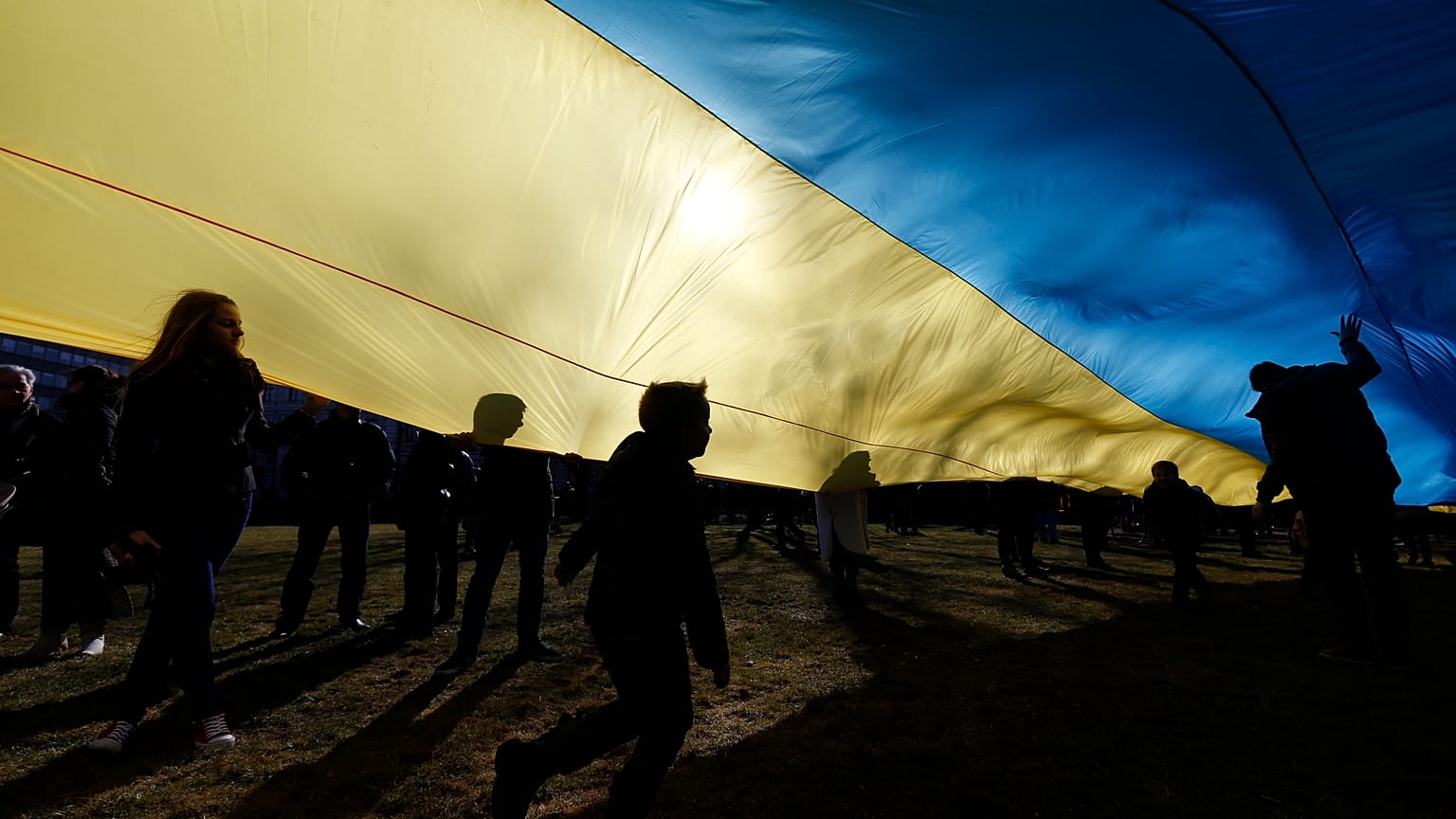 Archive : des enfants jouent sous un drapeau ukrainien géant pour protester contre l'intervention russe en Ukraine en 2014, en Lituanie.