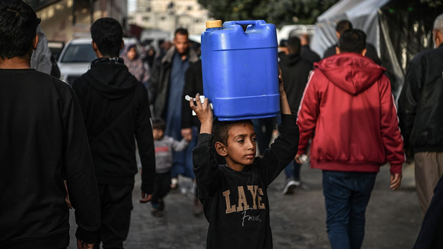 A child is seen as Palestinians meet their water needs from mobile tanks after great damage to the city's infrastructure due to Israeli attacks in Khan Yunis, Gaza 