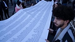 Tüntetők az Izrael-Hamász háború palesztin áldozatainak neveit tartalmazó lepedővel a ciszjordániai Ramallahban