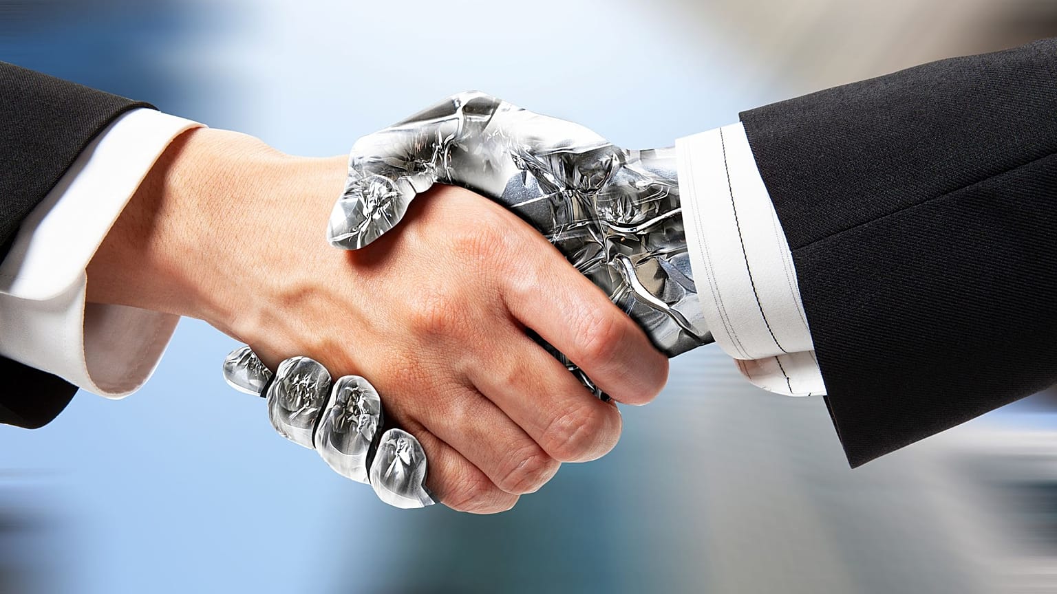 Un humano y un robot se dan la mano.