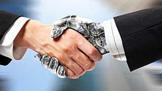 Un humano y un robot se dan la mano.