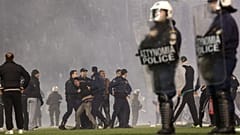 Policemen detain a fan of Panathinaikos during clashes at the pitch of Apostolos Nikolaides stadium  in Athens, Saturday, Nov. 21, 2015.