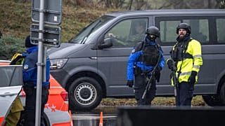 Police officers control cars near Saint Maurice, as they search for a gunman who killed two people and injured another in the southern Swiss town of Sion, on December 11, 2023