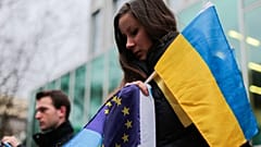 Un manifestante con una bandera ucraniana y otra de la UE