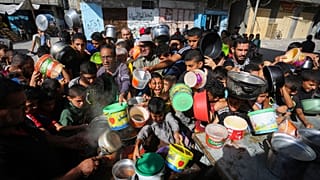 Gazze Şeridi'nin güneyinde Mısır sınırına yakın Refah semtinde yemek alabilmek için sırada bekleyen Filistinliler