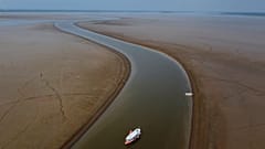 A ferry boat travels through a section of the Amazon River affected by a severe drought, near Manacapuru.