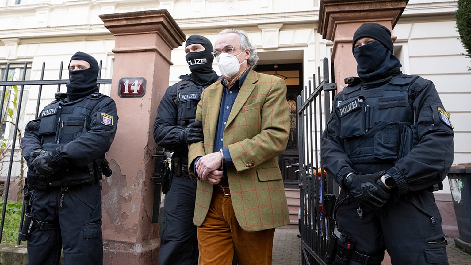 Agenti di polizia mascherati conducono Heinrich XIII Principe Reuss, a destra, verso un veicolo della polizia durante un raid contro i cosiddetti "cittadini del Reich" a Francoforte, in Germania.