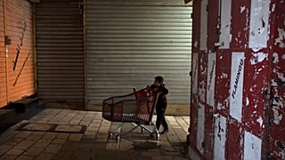 طفل فلسطيني يدفع عربة تسوق فارغة في أحد زقاق مدينة القدس