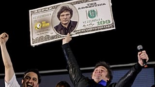 Javier Milei, Liberty Advances coalition presidential candidate, holds a cardboard image of a $100 dollar bill bedecked with an image of his face during his closing campaign.