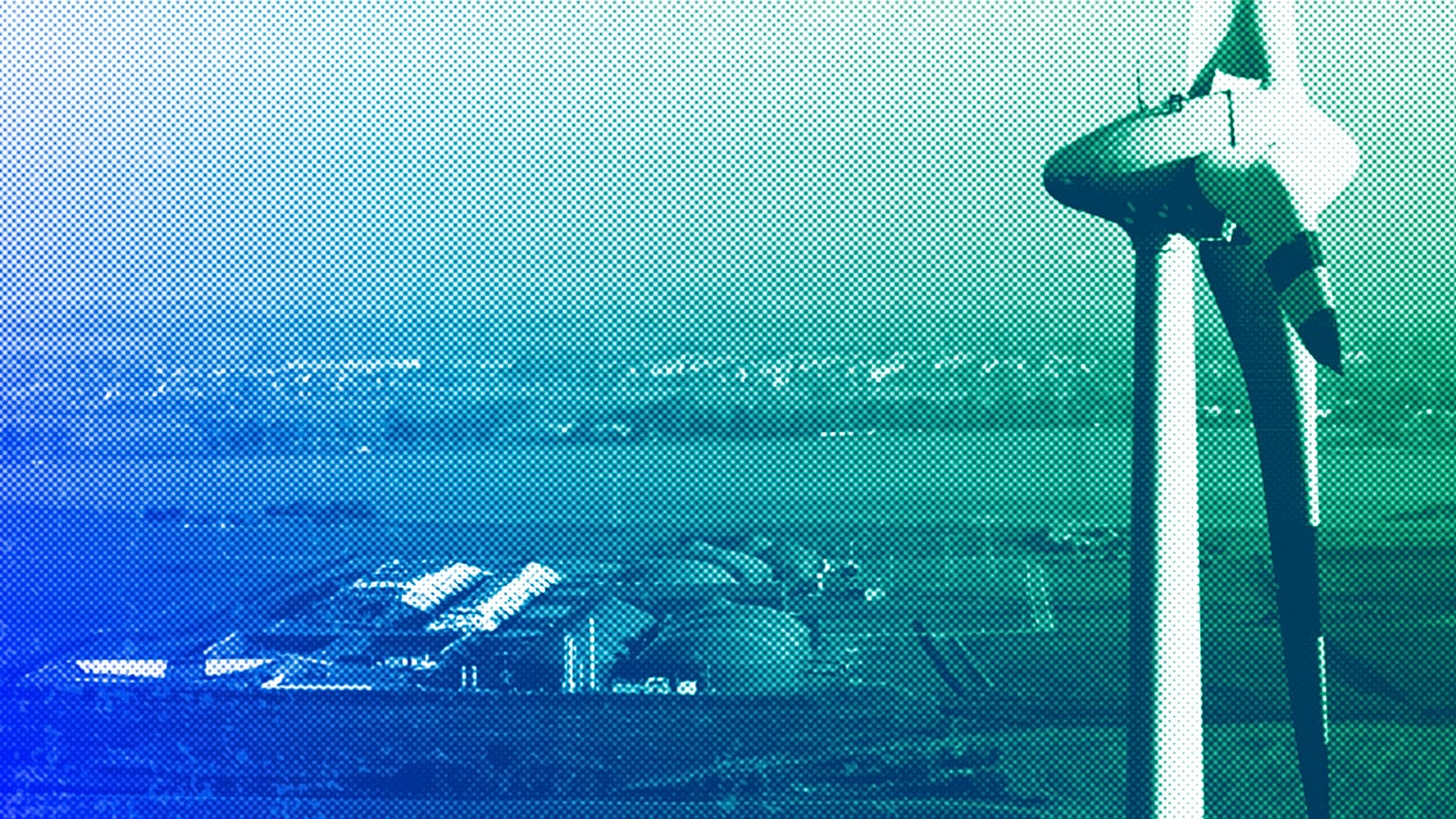 Por trás de uma turbina eólica em Nauen, Alemanha, em outubro de 2012, vê-se uma fábrica de biogás