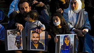 عائلة تحمل صور الصحفيين اللبنانيين الذين قتلوا في الغارات الإسرائيلية، خلال احتجاج أمام المتحف الوطني اللبناني في بيروت، لبنان 8 ديسمبر 2023