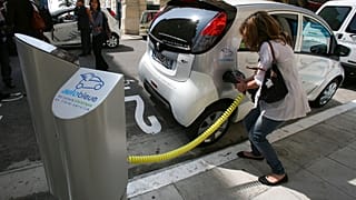Fransa'da elektrikli araç şarj eden bir kadın
