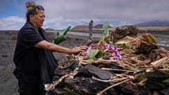 Kealoha Pisciotta, a cultural practitioner and longtime activist, lays offerings before praying at an "ahu," or ceremonial platform, part of the way up Mauna Kea 