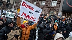 An activist holds a sign reading "Vitali Klitschko gives money for Movic (drone)" during a protest in front of city council of Kyiv