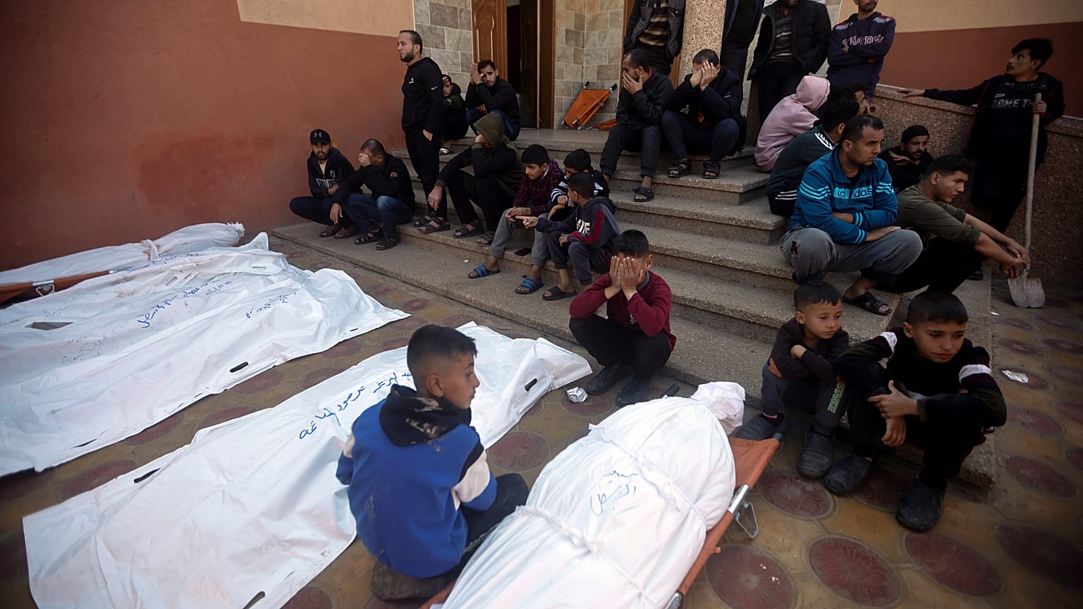 أطفال في غزة قرب جثث تعود لأفراد من عائلاتهم