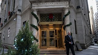 People walk in and out of the New York Stock Exchange (NYSE) at Wall Street on December 14, 2023 in New York City. Global equities made cautious gains Thursday with Frankfurt 
