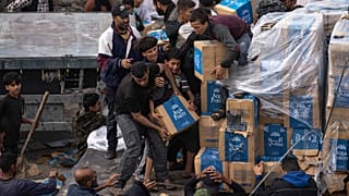 Palestinesi saccheggiano un camion di aiuti umanitari mentre attraversa la Striscia di Gaza a Rafah, domenica 17 dicembre 2023.