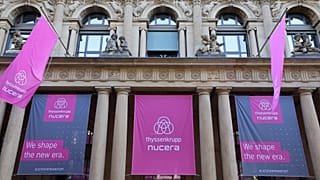 Banners with the logos of German industrial giant Thyssenkrupp and its hydrogen unit Nucera are seen on the facade of the Stock Exchange in Frankfurt am Main on July 7, 2023, 
