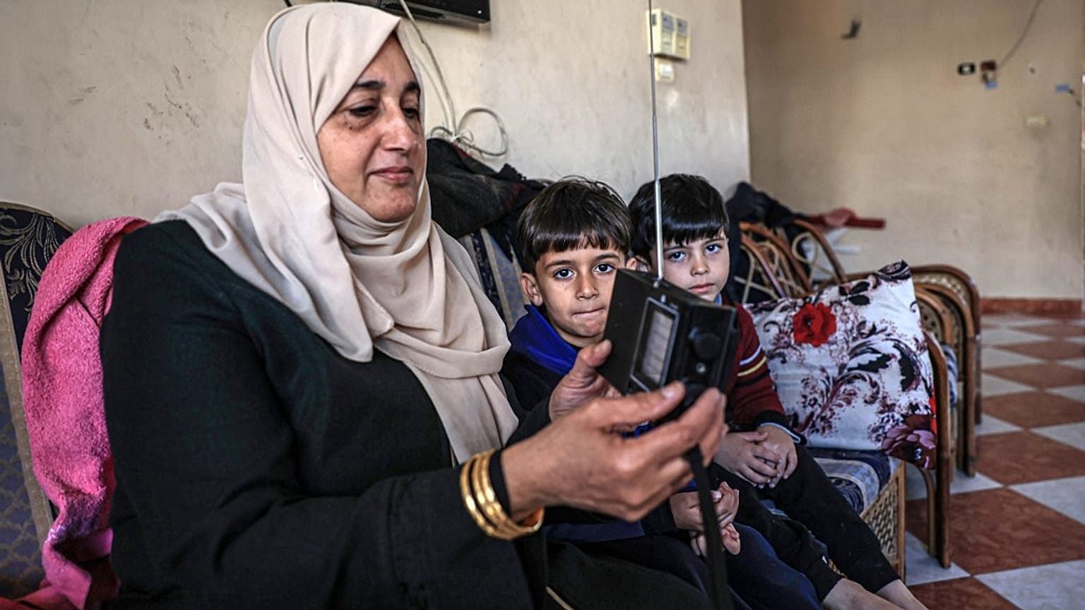 سيدة فلسطينية تستمع إلى الراديو في منزلها برفح جنوب قطاع غزة في 19 ديسمبر 2023.