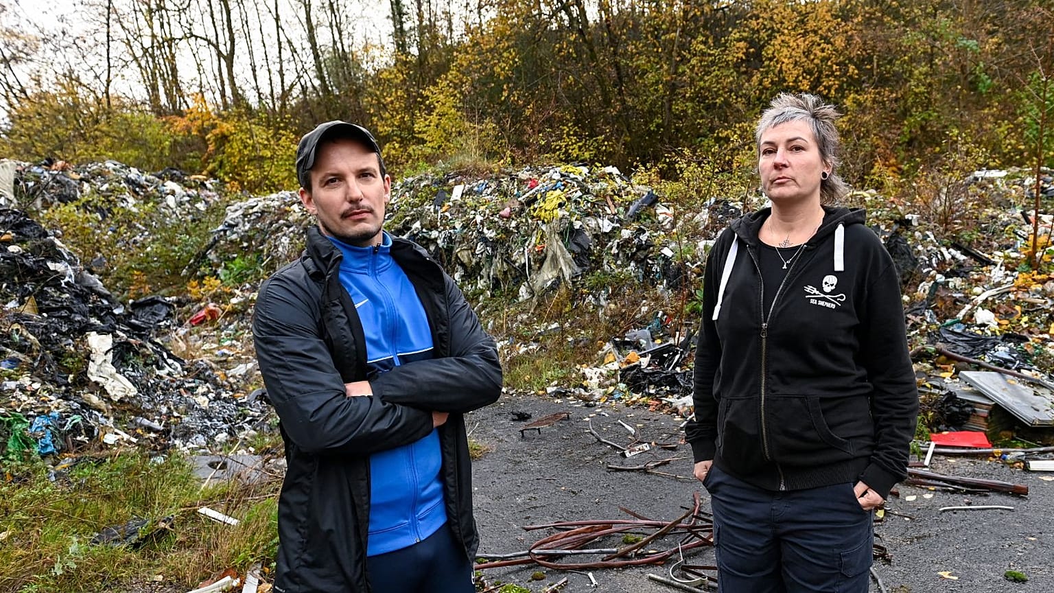 Jessica Dautruche, a member of the "J'aime ma forêt" (I love my forest) group and local resident Gautier Berera inspect a waste dump site near Rédange.