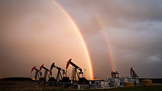 A rainbow appears to come down on pumpjacks drawing out oil and gas from wells near Calgary, Alberta, Monday, Sept. 18, 2023.