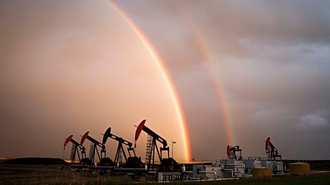A rainbow appears to come down on pumpjacks drawing out oil and gas from wells near Calgary, Alberta, Monday, Sept. 18, 2023.