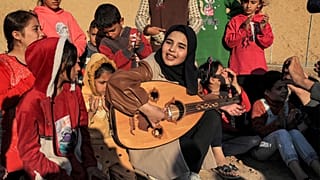  رؤيا حسونة تعزف العود وسط الأطفال في مخيم رفح