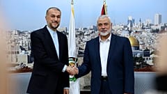 El ministro de Relaciones Exteriores de Irán, Hossein Amirabdollahian, le da la mano al jefe de Hamas, Ismail Haniyeh, durante su reunión en Doha, Qatar, el 20 de diciembre de