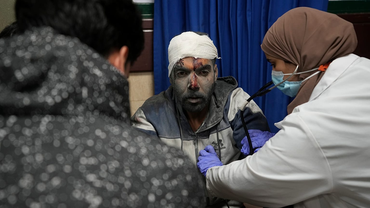 Palestinians wounded in the Israeli bombardment of the Gaza Strip are brought to the hospital in Deir al Balah, Gaza Strip, on Tuesday, Dec. 19, 2023.