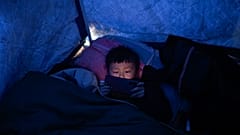 Un sobreviviente del terremoto sostiene un teléfono móvil en un refugio improvisado hecho de lona en Jishishan, en Gansu, en el noroeste de China, el 20 de diciembre de 2023.