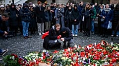 Mourners lay candle lights outside the headquarters of Charles University for victims of mass shooting in Prague, 22 December 2023