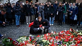 Mourners lay candle lights outside the headquarters of Charles University for victims of mass shooting in Prague, 22 December 2023