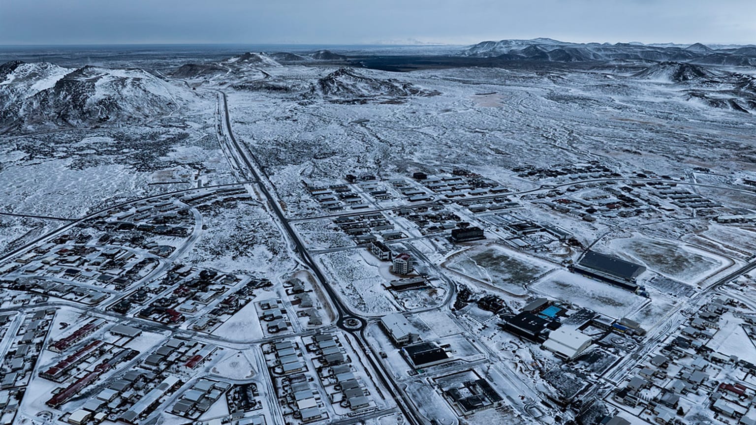 The lava field produced by the recent volcanic activity can be seen in the top background above Grindavik on Iceland's Reykjanes Peninsula, Thursday, Dec. 21, 2023.
