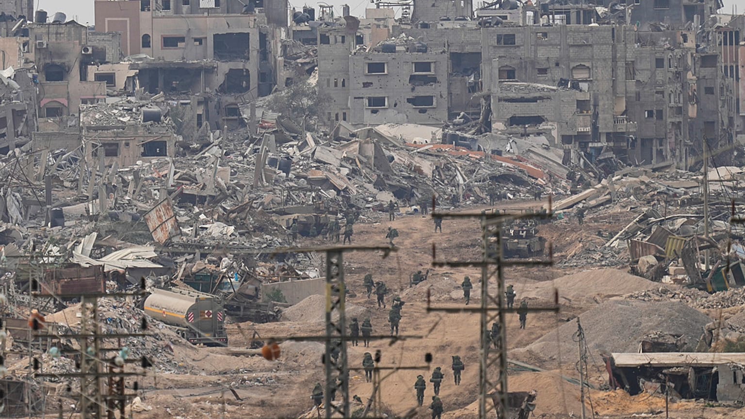 Israeli troops walk in the Gaza Strip as seen from southern Israel, Thursday, Dec. 21, 2023.