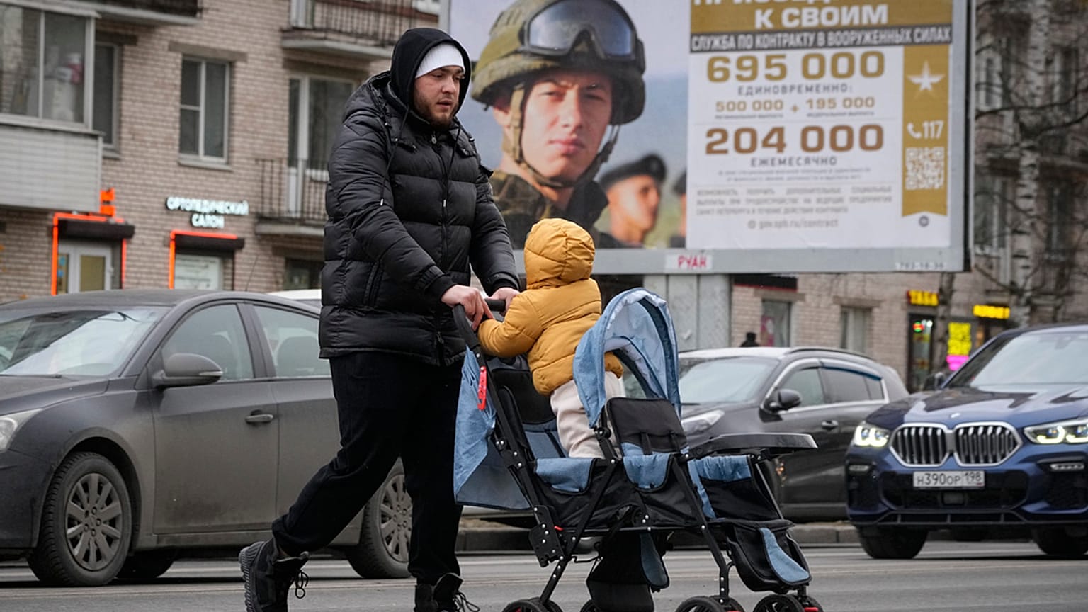 Мужчина с ребенком проходит мимо плаката о призыве в армию в Москве 