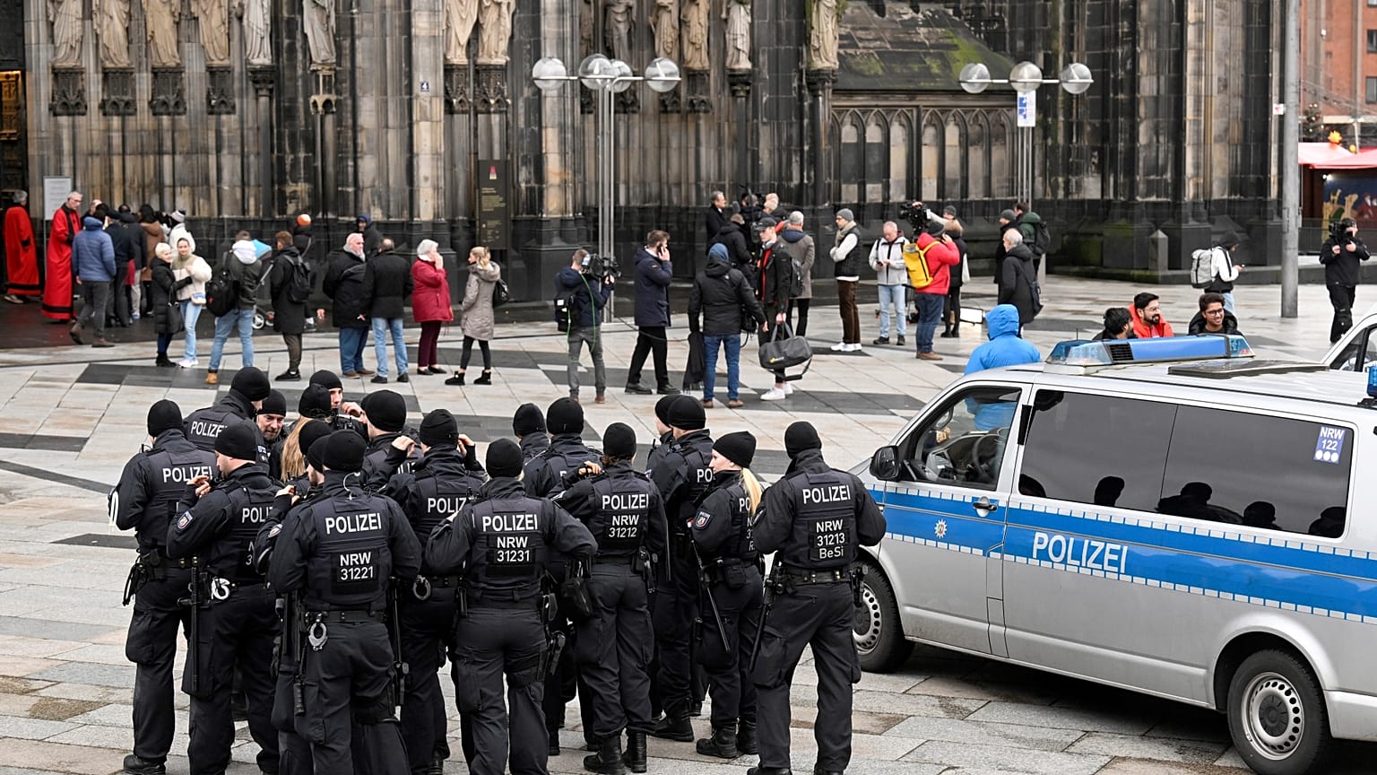 Des policiers patrouillent à l'entrée de la cathédrale de Cologne avant la messe de la veille de Noël, à Cologne, en Allemagne, le dimanche 24 décembre 2023.