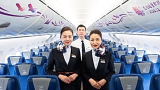 Members of the aircraft crew pose for photographs inside the Chinese-made C919 at the Hong Kong International Airport