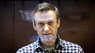 Russian opposition leader Alexei Navalny looks at photographers from inside a glass cage in the Babuskinsky District Court in Moscow, Russia, on Feb. 20, 2021