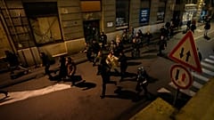Protesters run away from anti-riot police in Belgrade, Serbia, Sunday, Dec. 24, 2023.