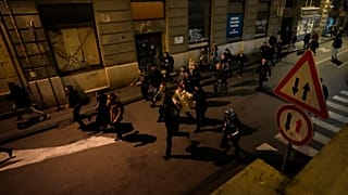 Protesters run away from anti-riot police in Belgrade, Serbia, Sunday, Dec. 24, 2023.