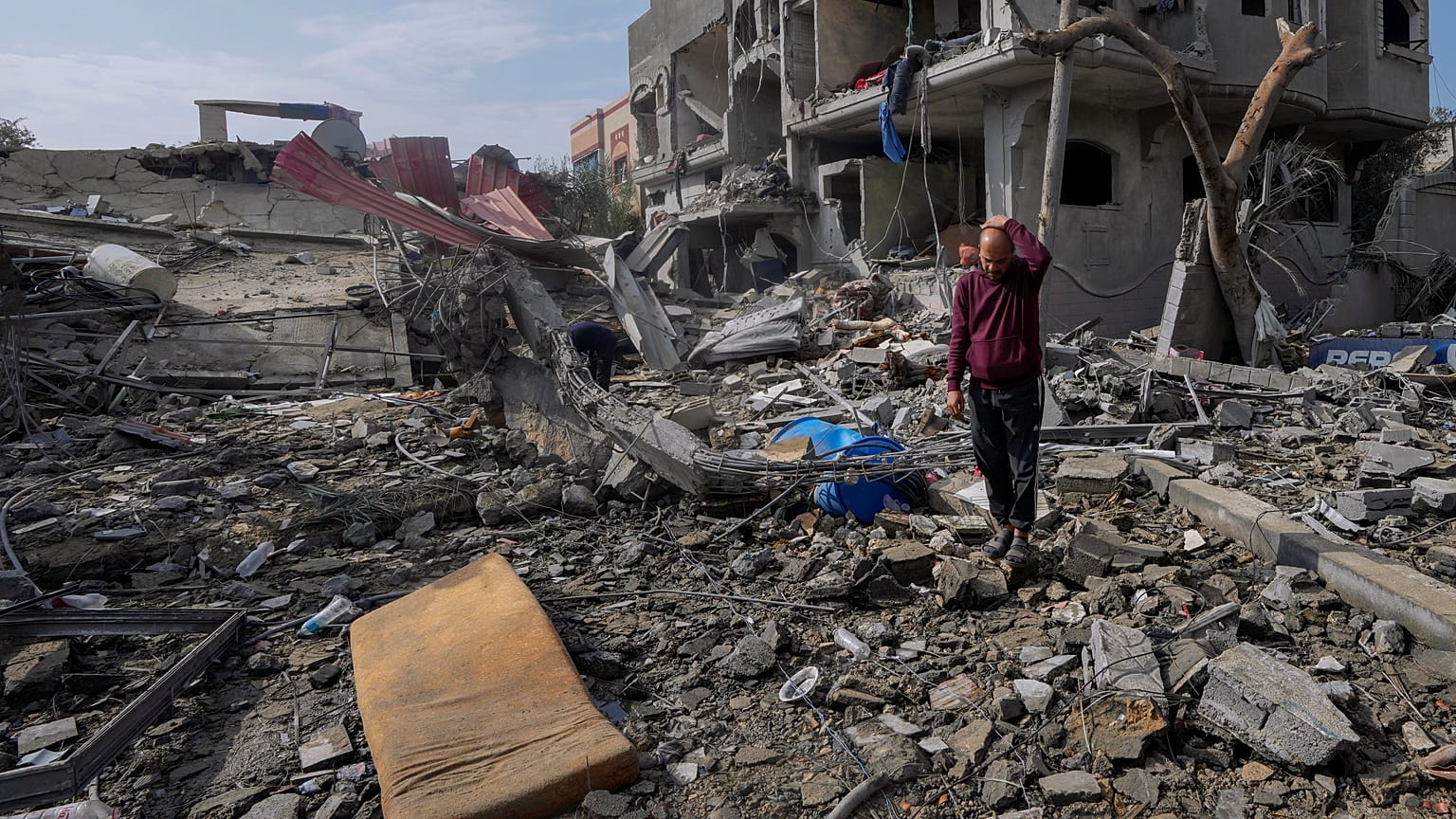 Palestinians inspect the rubble of a building of the Al Nawasrah family destroyed in an Israeli strike in Maghazi refugee camp, central Gaza Strip, Monday, Dec. 25, 2023