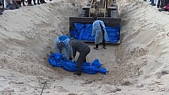 دفن عشرات جثامين الضحايا الفلسطينيين في مقبرة جماعية في رفح جنوب قطاع غزة. 2023/12/26