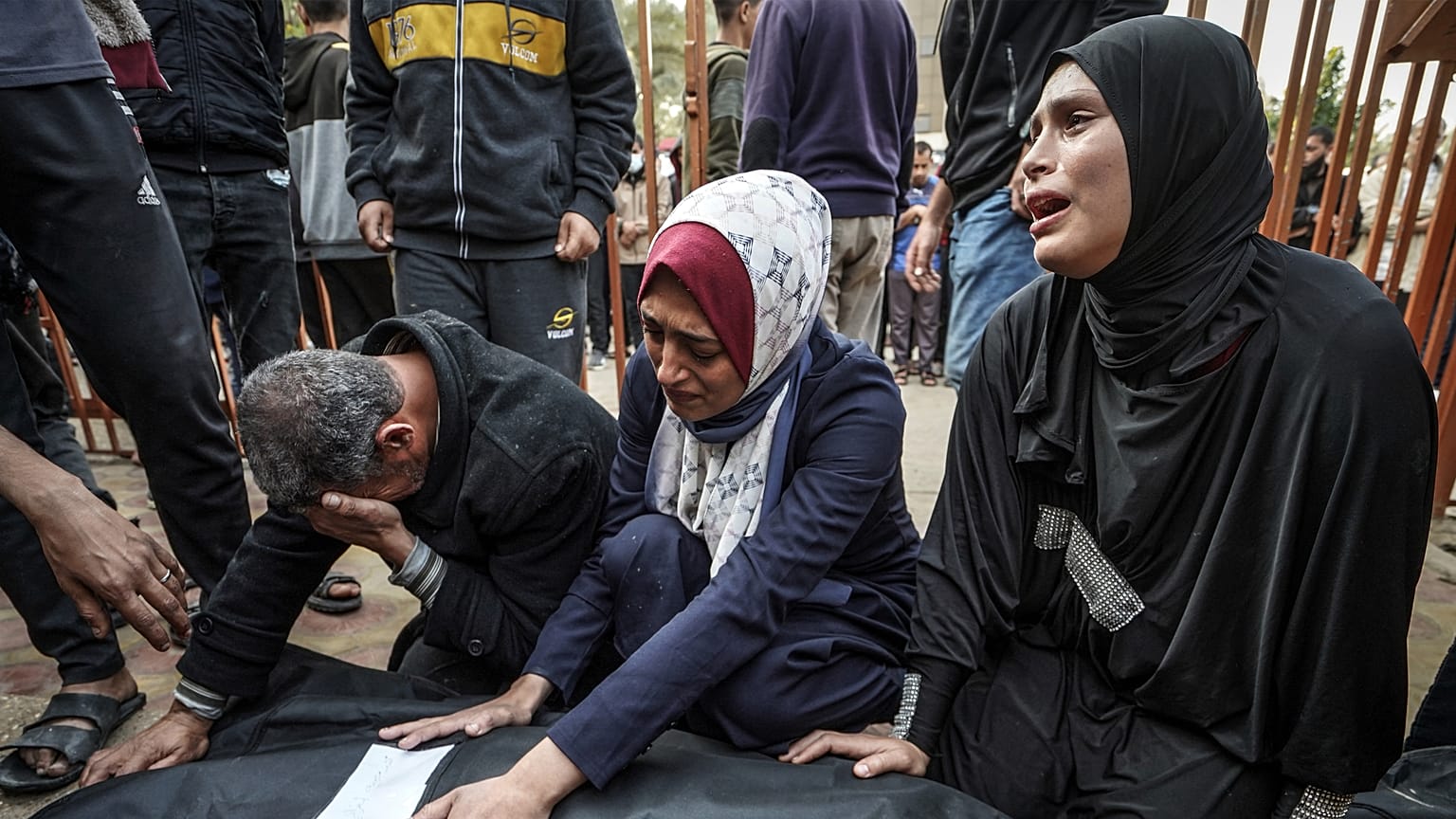 Relatives mourn over the body of a loved one killed during Israeli bombardment at Nasser Hospital in Khan Yunis
