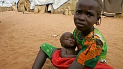 Una niña sudanesa con su hermanita en las afueras de la ciudad occidental de El-Geneina, cerca de la frontera con Chad, el 25 de octubre de 2004.