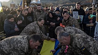 Ukrainische Soldaten drapieren auf dem Friedhof des Karpaten-Dorfs Krasnyk den Sarg des Armeeoffiziers Wassyl Medwijtschuk mit der Nationalflagge, 29. Dezember 2023. 