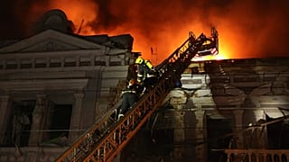 In this photo provided by the Ukrainian Emergency Service, firefighters put out a fire after Russia's missile attack in Kharkiv, Ukraine on Sunday