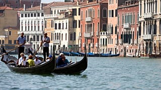 Turistas percorrem o Grande Canal em gôndolas tradicionais venezianas, em Veneza, Itália