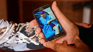 پدر سانتیاگو سانچز کوگدور عکس پسرش را بر روی موبایلش نشان می‌دهد