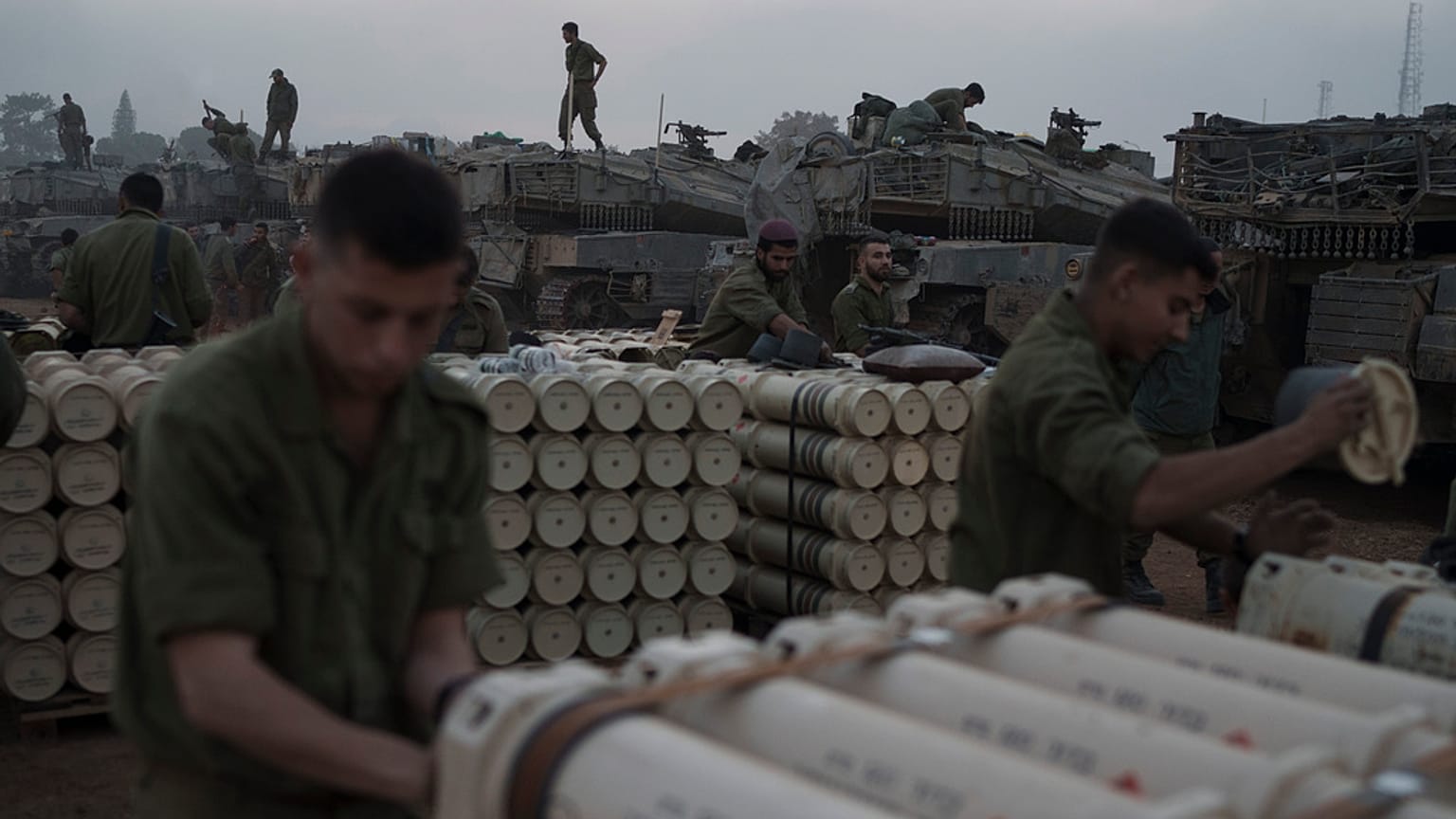 Israeli soldiers from the artillery unit store tank shells in a staging area at the Israeli-Gaza border in southern Israel